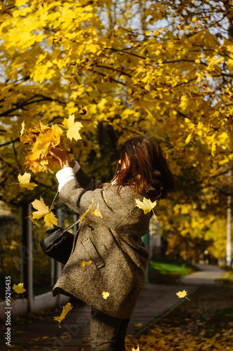 beautiful happy stylish brunette girl on a background of autumn