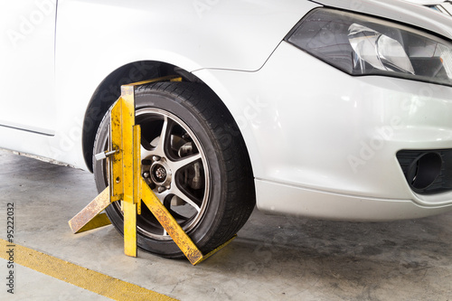 Car wheel clamped for illegal parking violation at car park © ThamKC