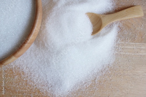 Fotografie white sugar in wood spoon on wood table