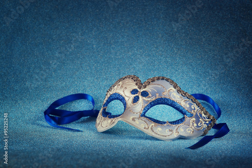 blue female carnival mask and glitter background 