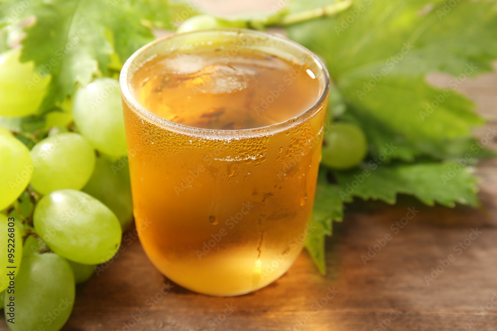 Glass of cool grape juice on wooden table, closeup Glass of cool grape juice on wooden table, closeup