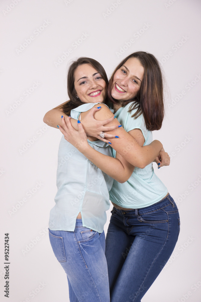 Two lookalike sisters, cute and intimate portrait in studio Two lookalike sisters, cute and intimate portrait in studio