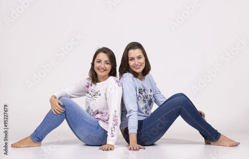 Two lookalike sisters, cute and intimate portrait in studio