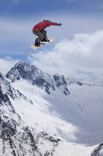 Flying snowboarder on mountains  extreme sport