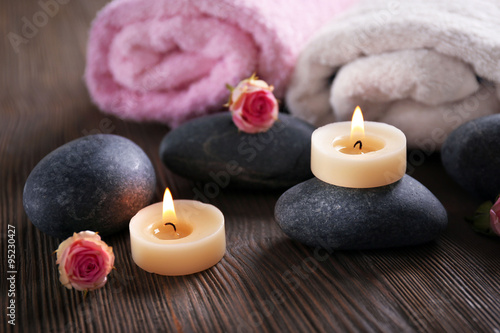 Spa composition of candles  flowers and stones on brown wooden background