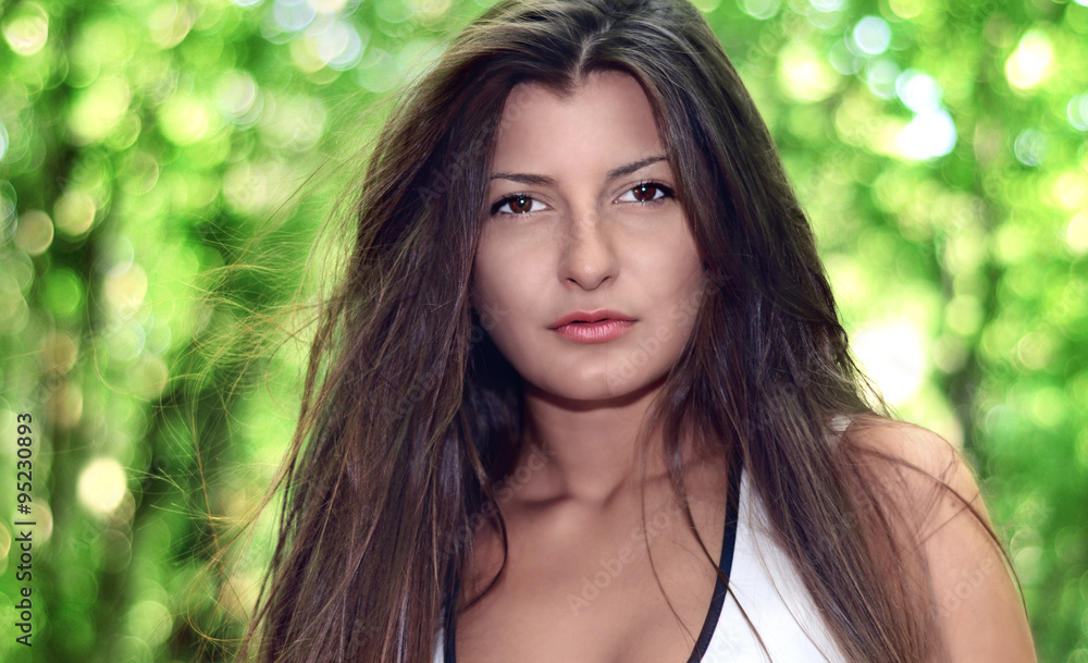 Beautiful sexy girl looking at you against spring green bokeh ba Beautiful sexy girl looking at you against spring green bokeh ba
