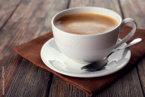 Cup of coffee on brown napkin closeup