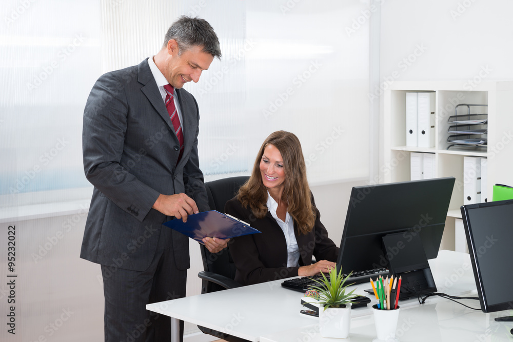 Businessman Showing Report To Female Employee Businessman Showing Report To Female Employee