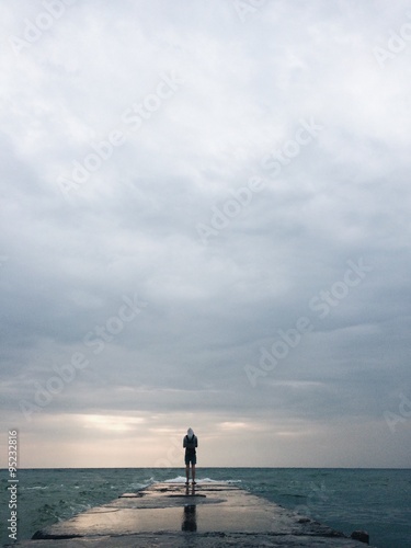lonely man silhouette on the old sea pier © Yevhenii Kukulka