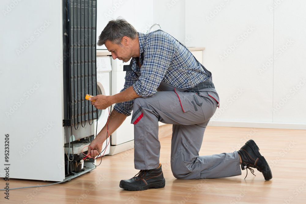 Technician Checking Fridge With Multimeter At Home Technician Checking Fridge With Multimeter At Home