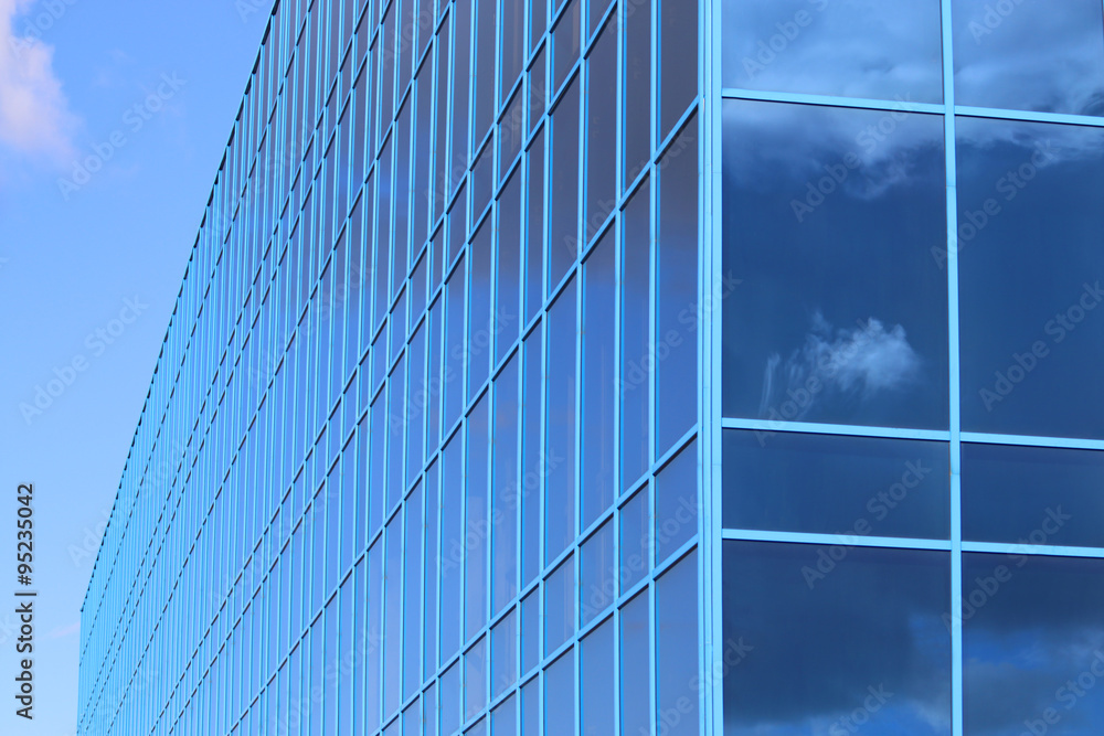 Part of modern new building with windows with reflected sky Part of modern new building with windows with reflected sky
