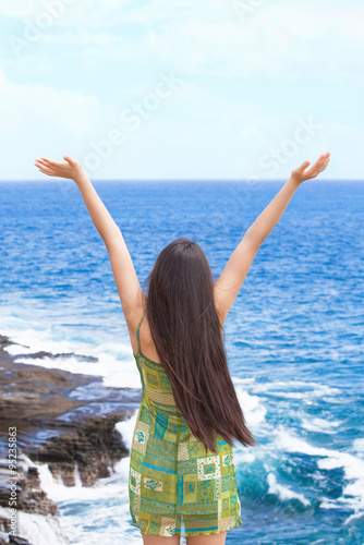 Biracial teen girl arms raised by ocean water in praise © Jaren Wicklund