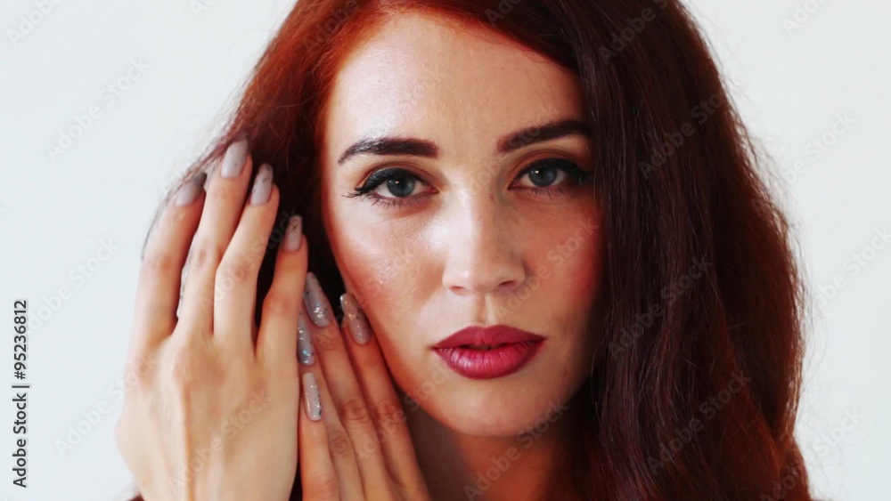 Red hair beautiful woman looks at camera and touches her face
Red hair beautiful woman looks at camera and touches her face