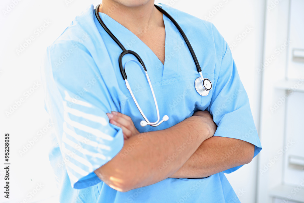 Portrait of unknown male surgeon doctor holding his stethoscope, crossed arms Portrait of unknown male surgeon doctor holding his stethoscope, crossed arms