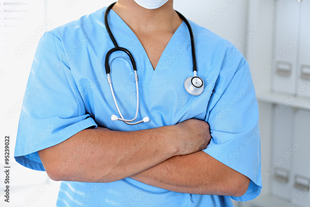 Portrait of unknown male surgeon doctor holding his stethoscope, crossed arms Portrait of unknown male surgeon doctor holding his stethoscope, crossed arms
