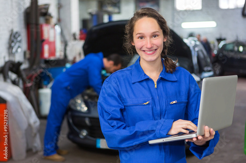 Young attractive woman mechanic working at the garage photo