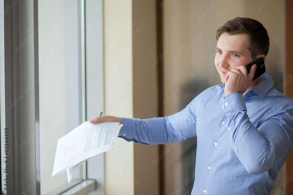 Fototapeta premium Happy businessman talking on the phone at office