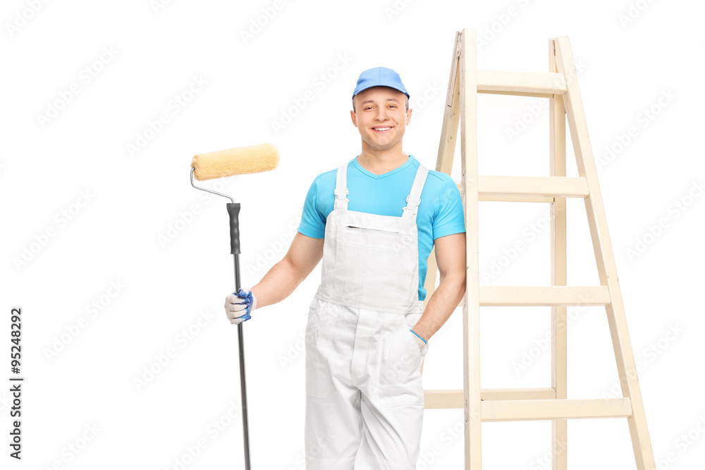 Painter holding a paint roller and leaning on wall Painter holding a paint roller and leaning on wall