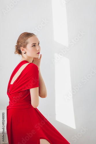 Young girl in a red dress on a white background