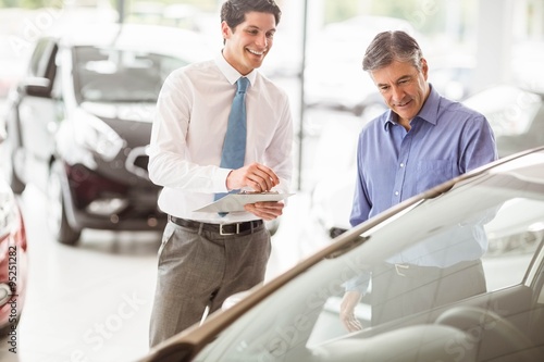 A man showing a car to the salesman