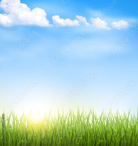 Green grass lawn with clouds and sun on blue sky