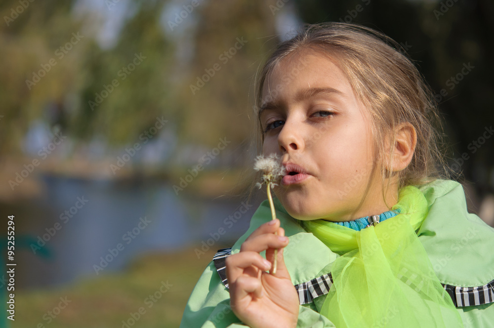 girl blowing dandelion white in the autumn park. girl in a green jacket in the fall
girl blowing dandelion white in the autumn park. girl in a green jacket in the fall