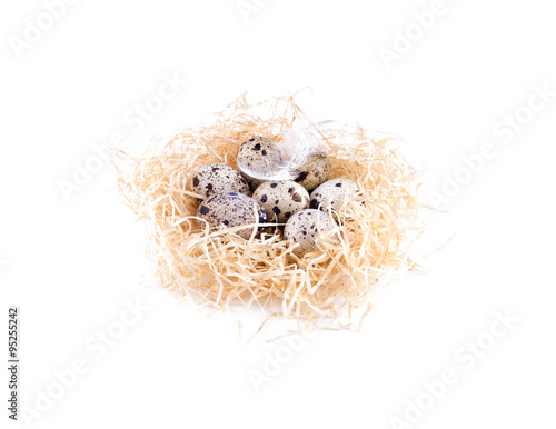 Nest with quail eggs side view. Straw, quail eggs, isolated.