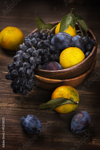 Fresh organic fruits in a wooden bowl. Rustic style. Toned image. Selective focus