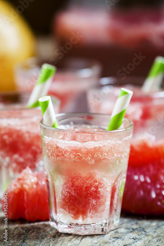 Cocktail with vodka, soda and grapefruit with striped straws, se