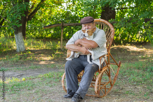 Young basenji sitting with master on a wicker chair photo