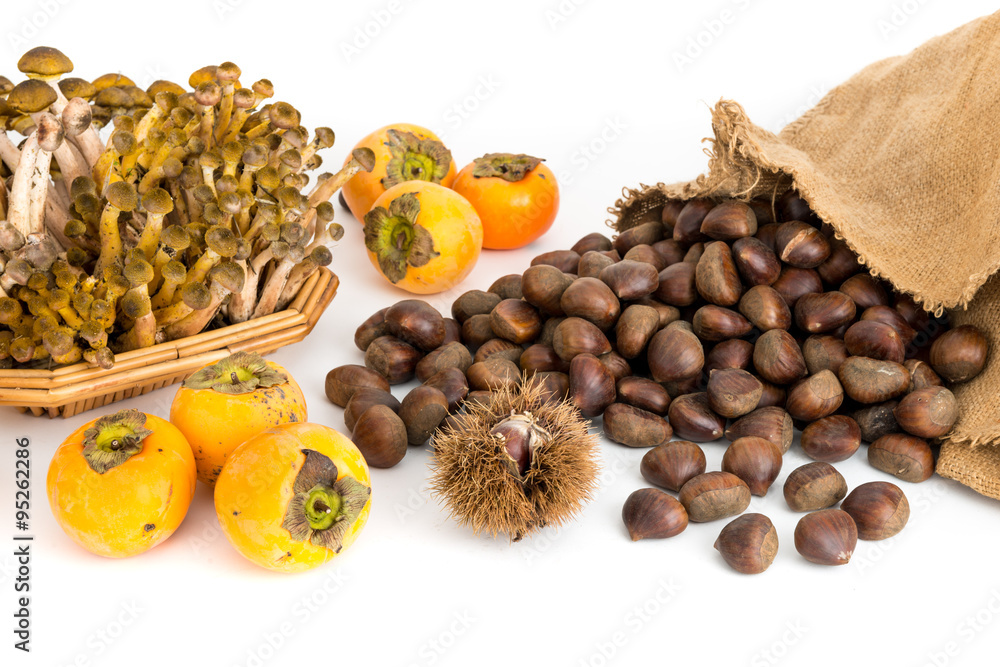 Obraz premium Frutti autunnali funghi cachi e castagne su sfondo bianco