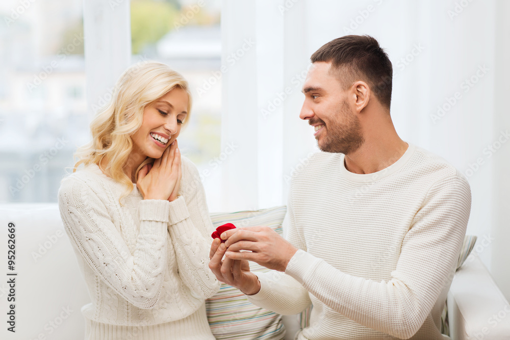happy man giving engagement ring to woman at home happy man giving engagement ring to woman at home