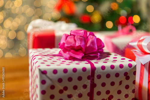 close up of gift boxes over christmas tree lights photo