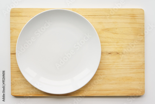  View from above Empty plate on wooden cooking board, white back