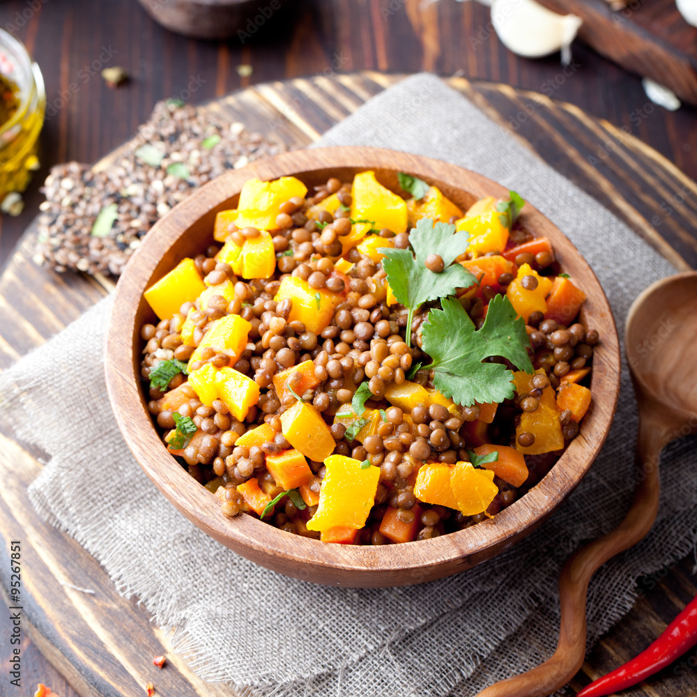 Fototapeta premium Lentil with carrot and pumpkin ragout in a wooden bowl.