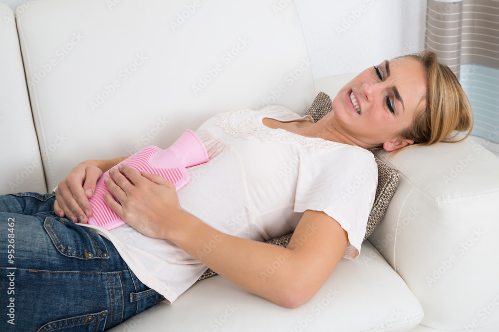 Woman Holding Hot Water Bag On Stomach At Home Woman Holding Hot Water Bag On Stomach At Home