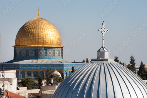 The silver dome of Our Lady of the Spasm Armenian Catholic Church and the golden Dome of the Rock rise over the Old City of Jerusalem.