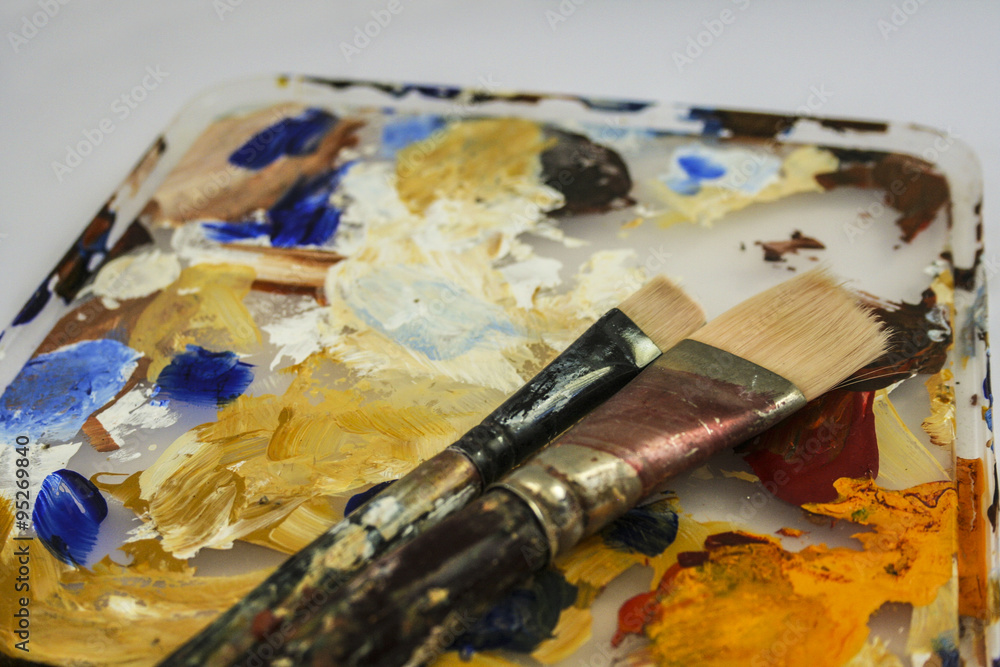 Obraz premium Two paint brushes on paint palette.