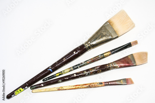 Group of four paint brushes spread out.