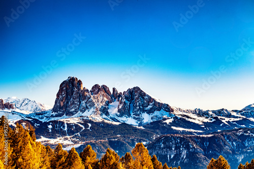 Dolomite mountains covered with white snow and green conifers