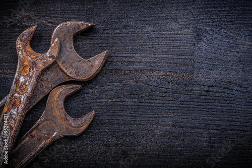 Composition of vintage spanner wrenches on wood board constructi photo