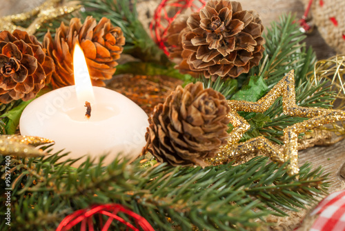 Christmas candle and ornaments: Christmas wreath, pine branches, pine cones, yellow glitter Christmas stars and Christmas balls © raresb