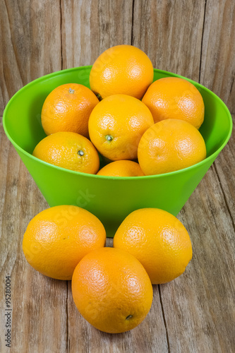 several pieces of orange fruit in a green bowl
