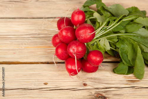 Fresh radishes on old wooden table