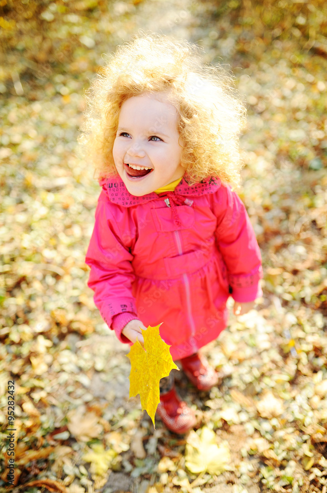 curly haired little girl playing on the autumn background curly haired little girl playing on the autumn background
