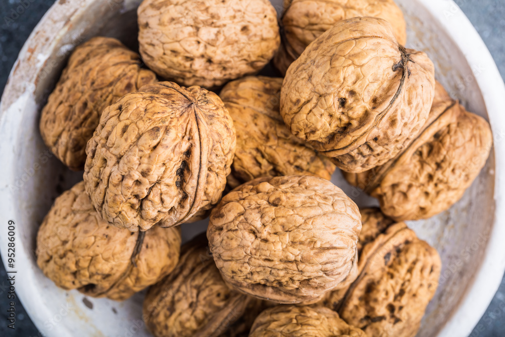 Walnuts in a white bowl on a black background Walnuts in a white bowl on a black background