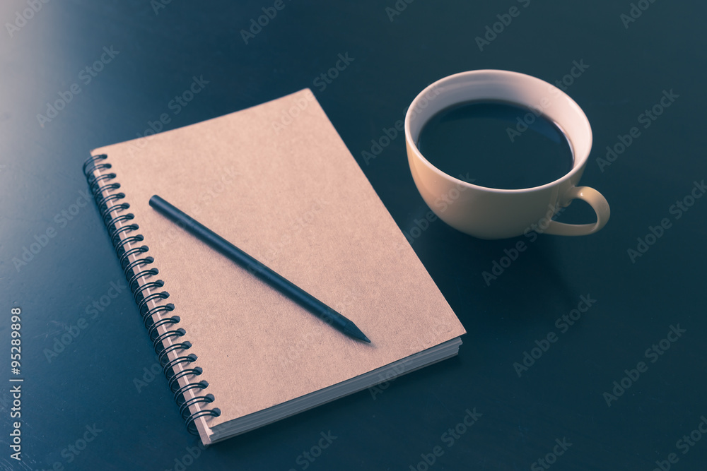 Book and coffee cup on black wooden table Book and coffee cup on black wooden table