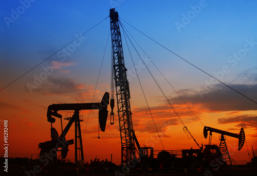 The evening of the oilfield, pumping unit and the silhouette of