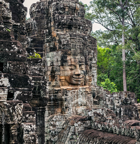 Detail of the tower with a relief image of Buddha in the temple of Angkor Thom. photo