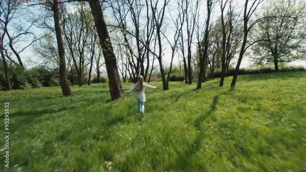 Cheerful girl running away from the camera in the park Cheerful girl running away from the camera in the park